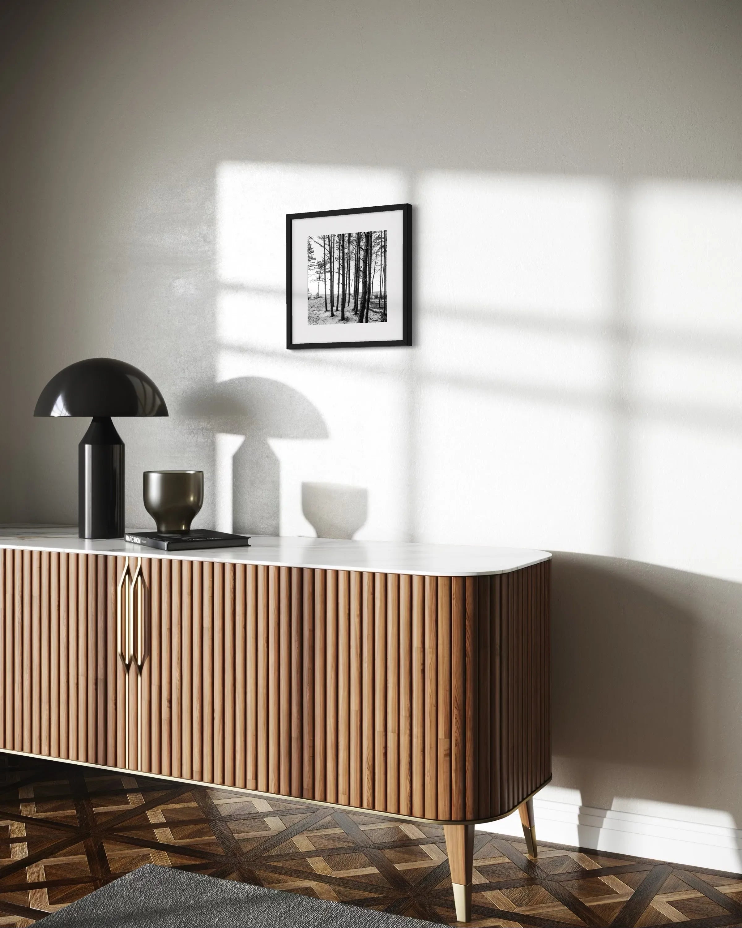 Framed fine art print Dunes I by Ziggy Kańczukowski displayed on a white wall above a wooden sideboard with decorative lamps in a modern interior.
