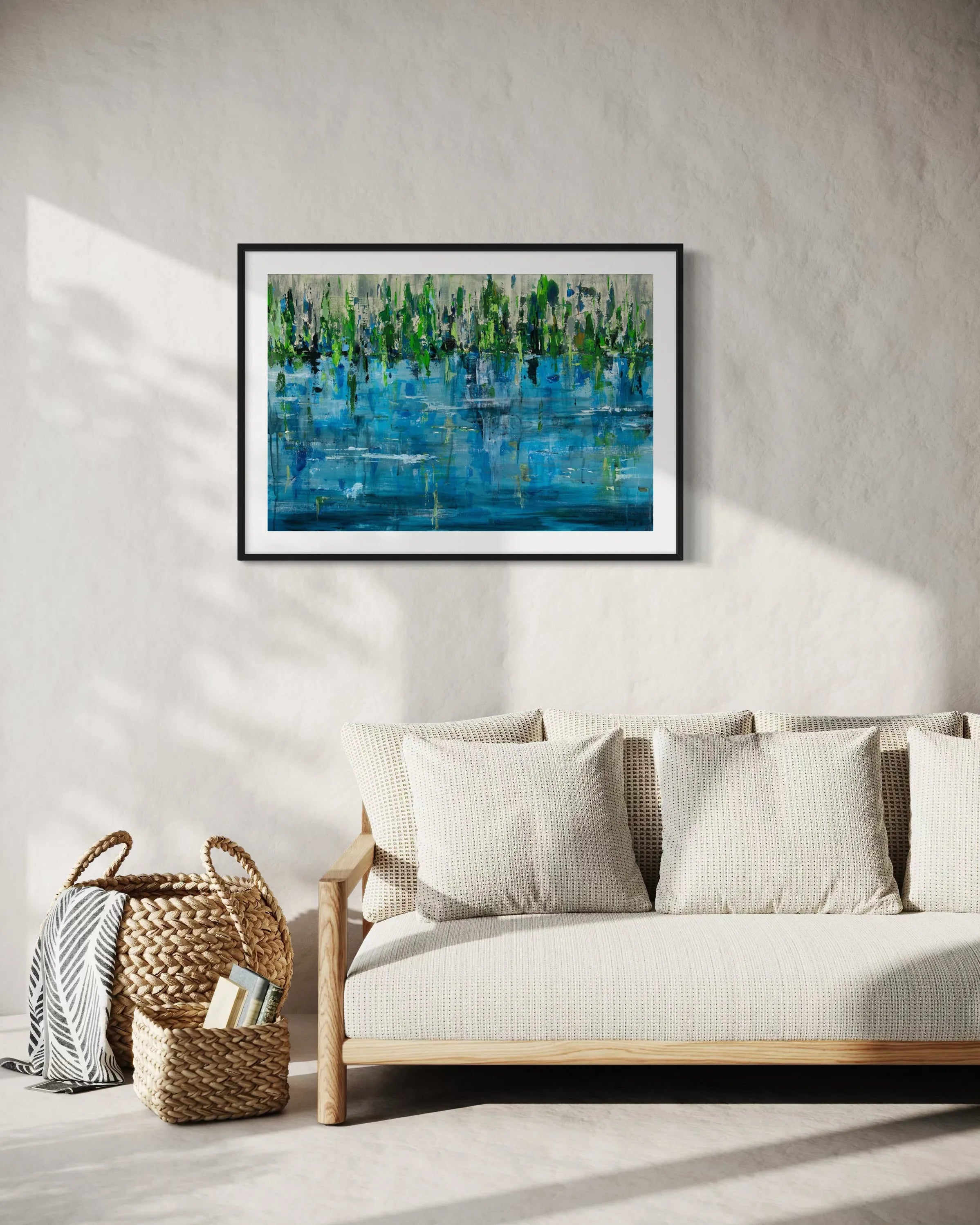Framed abstract painting Pond by Oliwia Tomczak displayed on a wall above a sofa in a living room.