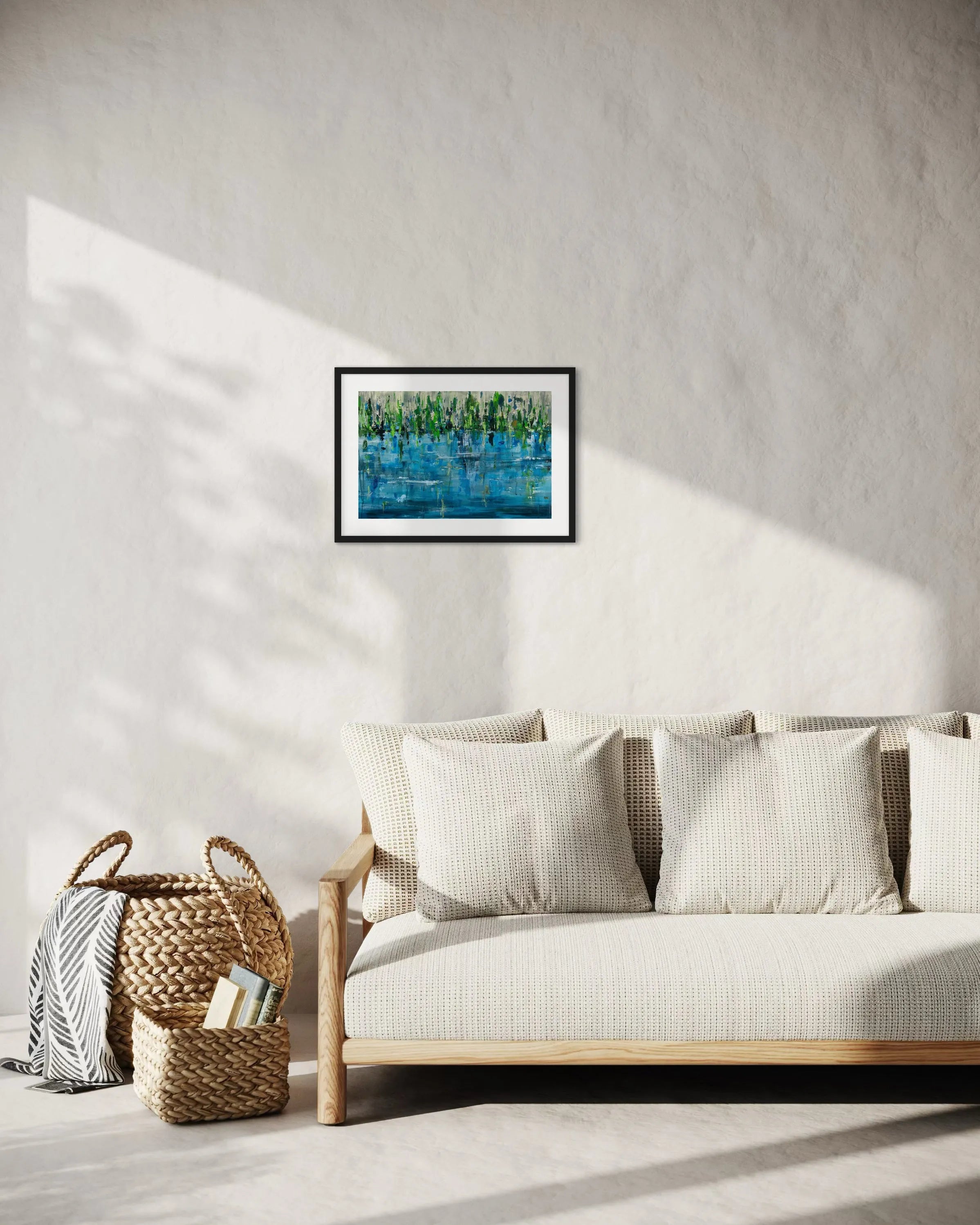 Framed abstract painting Pond by Oliwia Tomczak displayed on a wall above a sofa in a living room.