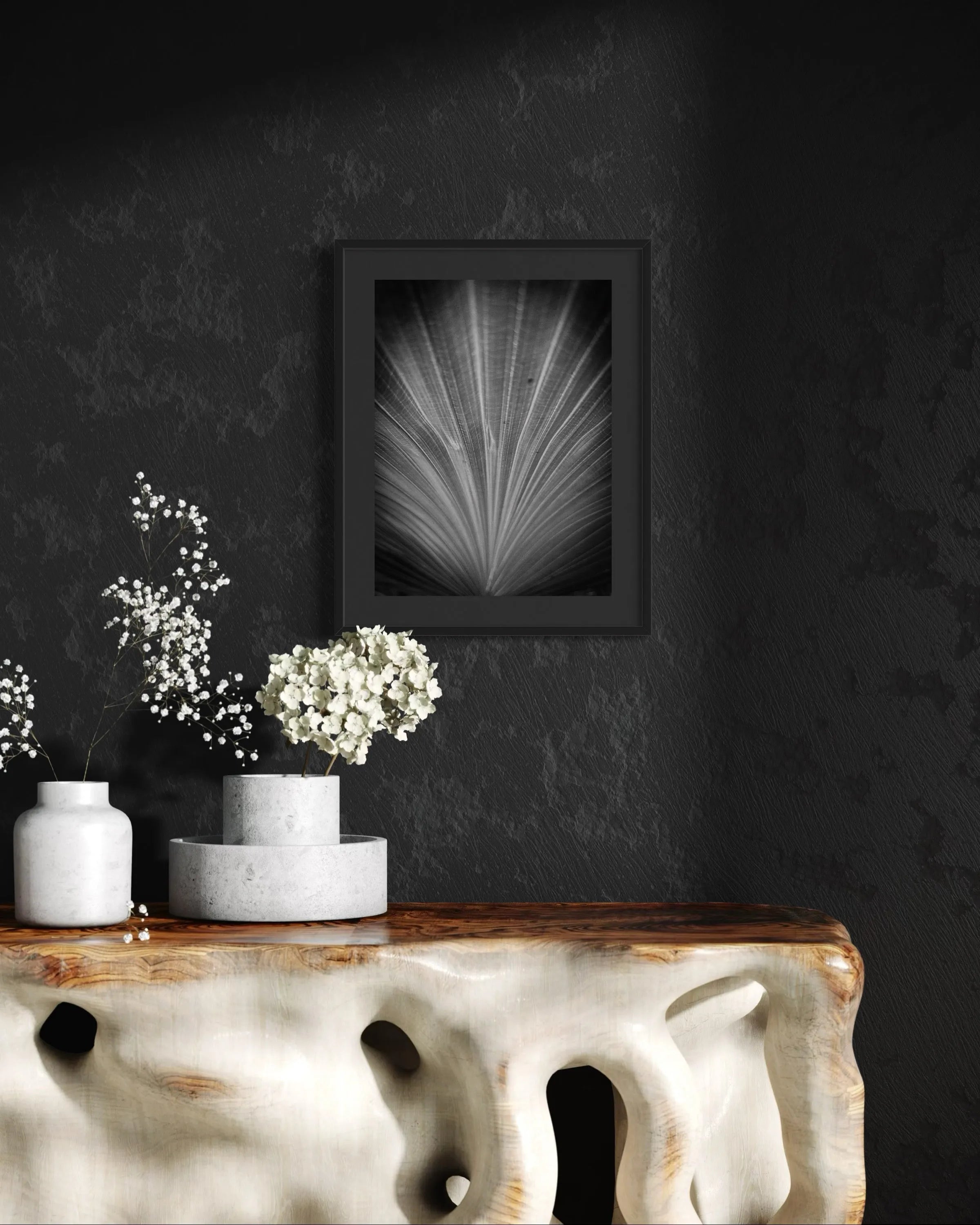 Framed black and white fine art print Structure 05 by Ziggy Kańczukowski displayed on a dark wall above a console table featuring decorative vases and flowers.