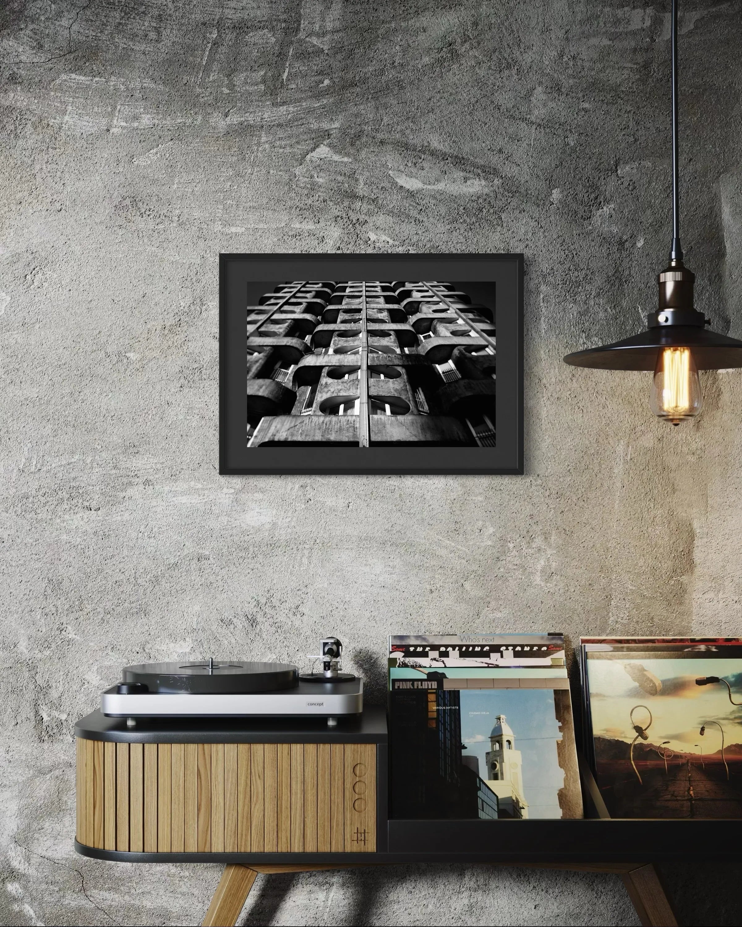Framed black and white fine art print Structure 04 by Ziggy Kańczukowski displayed above a record player and collection on a concrete wall.