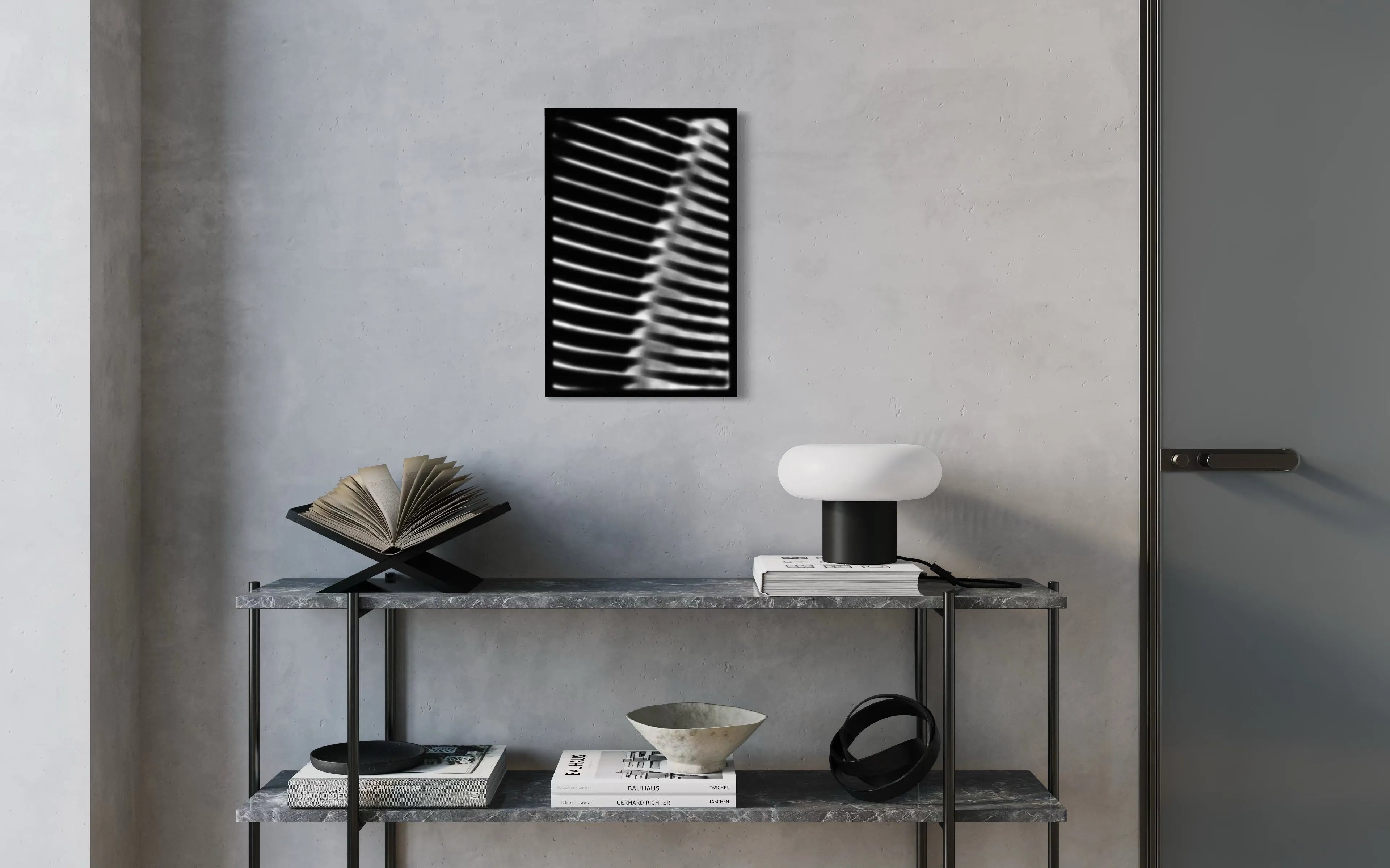 Framed fine art print Machine 02 by Ziggy Kańczukowski displayed on a shelf with books and a lamp against a gray wall in a modern interior.