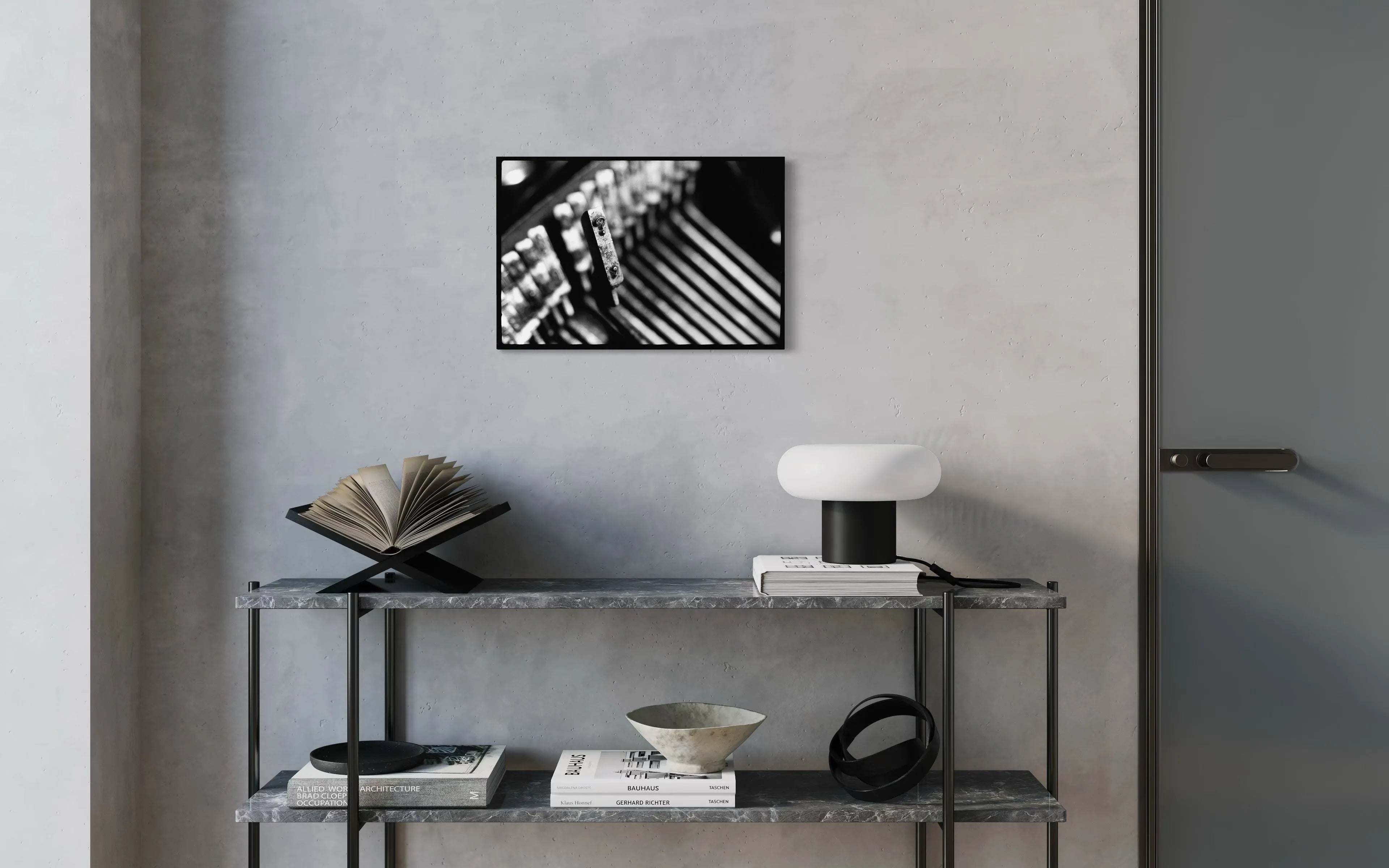 Framed black and white fine art print Machine 03 by Ziggy Kańczukowski displayed on a shelf against a gray wall in a modern interior.
