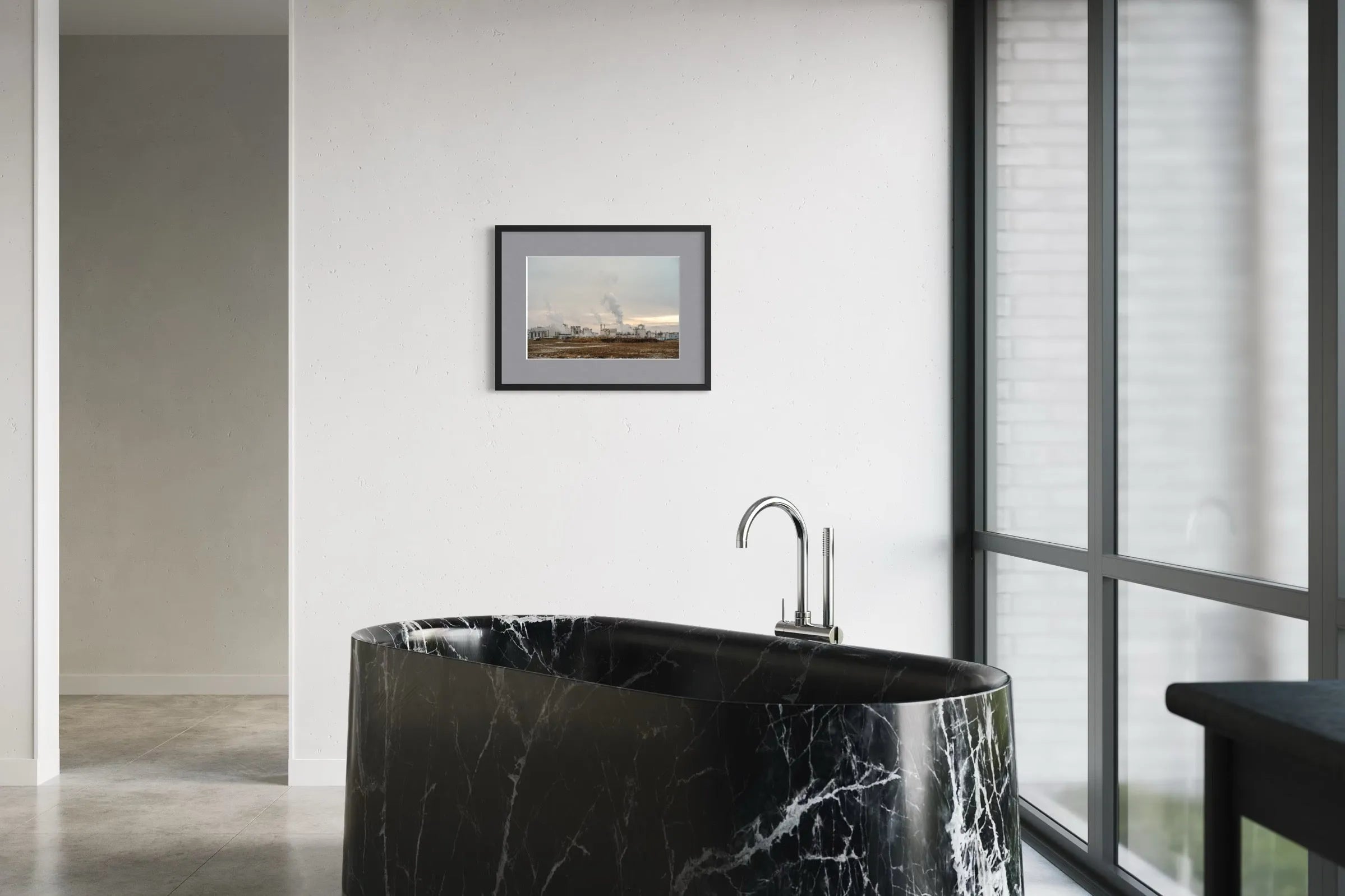 Modern bathroom with a black marble freestanding bathtub and the framed color fine art photograph Smoke by Ziggy Kańczukowski on the wall.